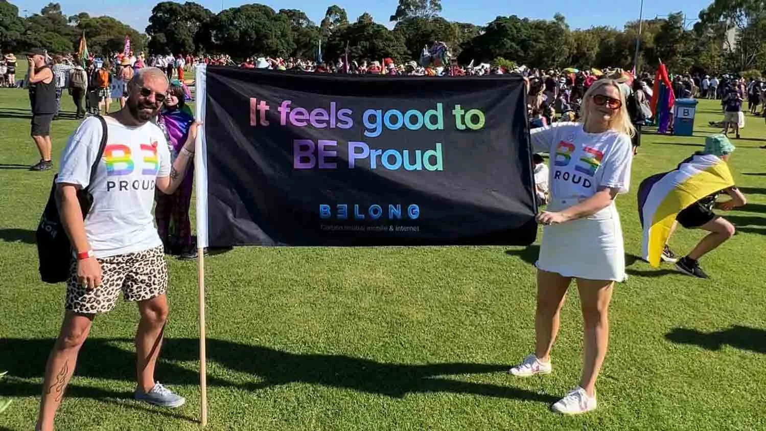 Jarrod and Hannah from Belong hold a sign that says “It feels good to BE Proud” in the marshall area of Midsumma Pride March.